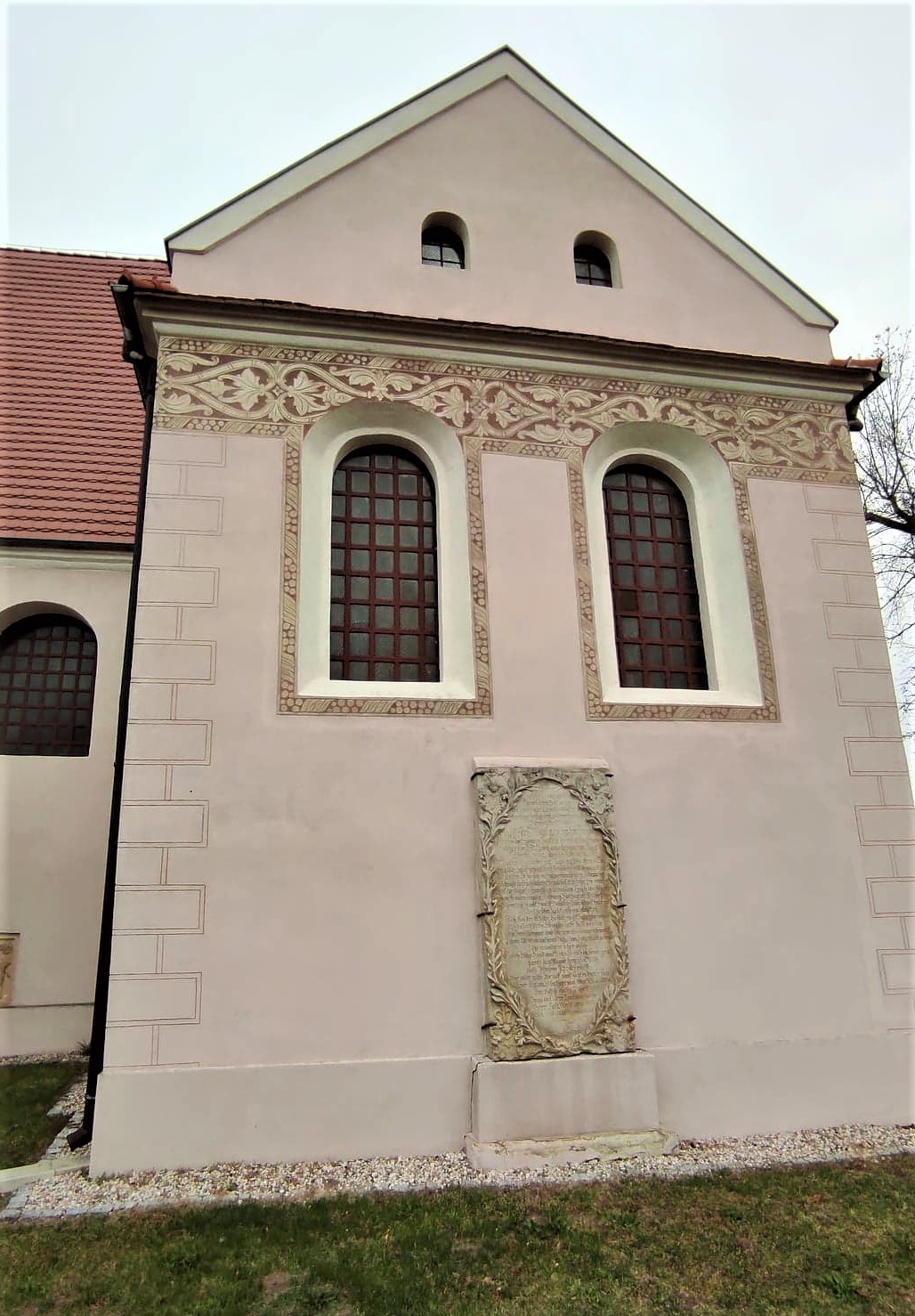 Elewacja kaplicy z roślinnymi motywami wykonanymi technika sgraffita ściennego